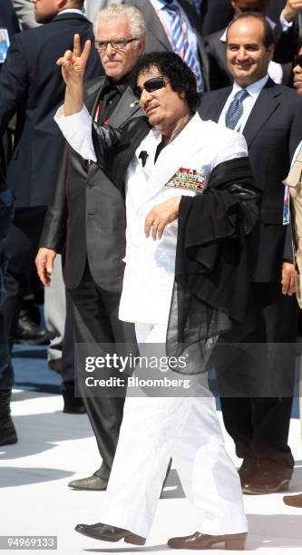 Muammar Qaddafi, Libya's leader, center, gestures as he arrives for the Food Security session at the G8 summit in L'Aquila, Italy, on Friday, July...