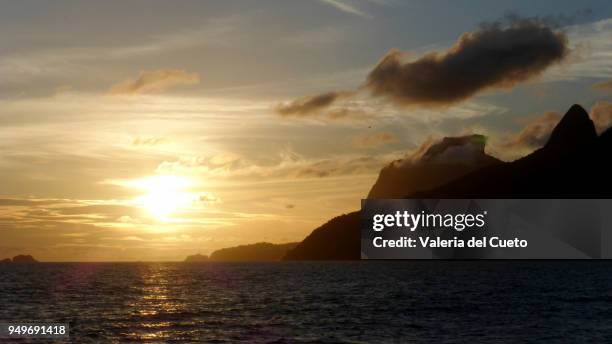 sea, mountain and sun falling - valeria del cueto stock pictures, royalty-free photos & images