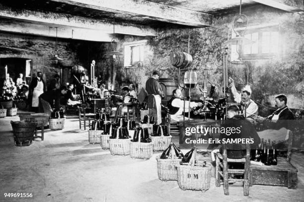 Between 1930 and 1950, the wine growers of the champagne house AYALA effect the phase of discharging the champagne, Equipped with a pair of tongs,...