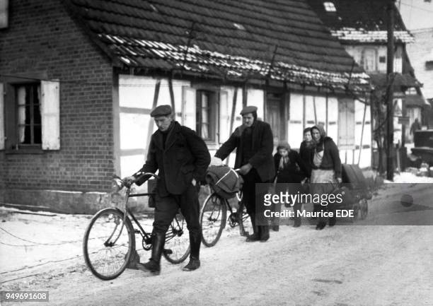 Civilians fleeing the zone of combat in Alsace in December 1944 after a German counter-offensive in the town of Rittershoffen. En Alsace, en décembre...