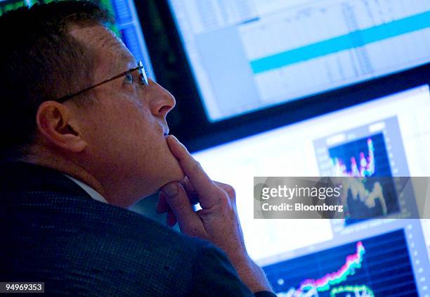 Trader looks up at a monitor while working on the floor of the New York Stock Exchange in New York, U.S., on Monday, July 13, 2009. U.S. Stocks...