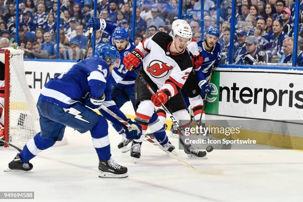 New Jersey Devils defender Mirco Mueller plays the puck off the boards as he is pressured by Tampa Bay Lightning left wing Chris Kunitz during the...