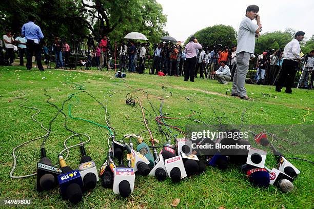 Microphones lie in the grass as reporters wait to speak to representatives of Reliance Natural Resources Ltd. And Reliance Industries Ltd. After a...