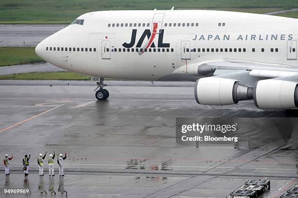 Airport ground staff monitor a Japan Airlines Corp. Airplane at Haneda Airport in Tokyo, Japan, on Tuesday, July 21, 2009. American Airlines, the...