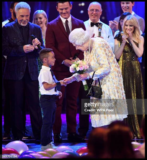 Queen Elizabeth II receives a bouquet of flowers at a star-studded concert to celebrate the her 92nd birthday at the Royal Albert Hall on April 21,...