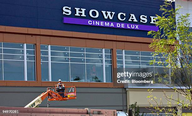 Worker uses a lift outside a Showcase cinema complex, a brand of National Amusements Inc., in Dedham, Massachusetts, U.S., on Tuesday, July 28, 2009....
