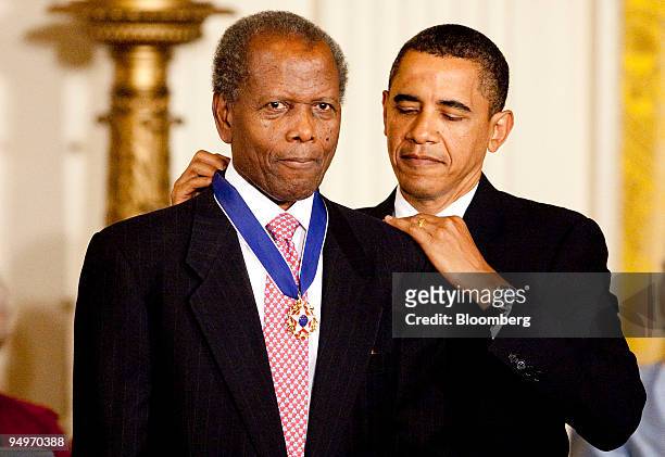Actor Sidney Poitier receives the 2009 Presidential Medal of Freedom from U.S. President Barack Obama during a ceremony in the East Room of the White...