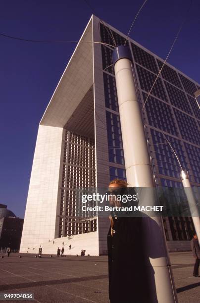 Employée téléphonant au pied de la Grande Arche de la Fraternité, dans le quartier de la Défense à Puteaux, dans les Hauts-de-Seine, France.