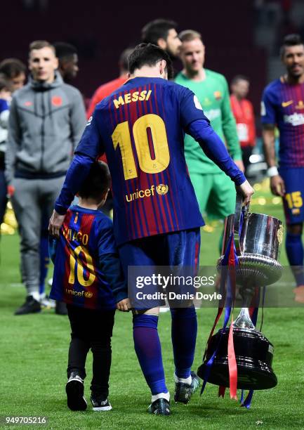 Lionel Messi of Barcelona walks away with the cup during the Spanish Copa del Rey Final between Barcelona and Sevilla at Wanda Metropolitano on April...