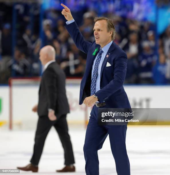 Head coach Jon Cooper of the Tampa Bay Lightning celebrates a series win as head coach John Hynes of the New Jersey Devils walks off after Game Five...
