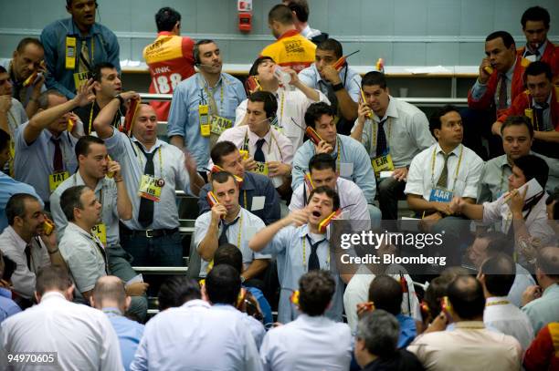 Traders signal orders at the Brazilian Bolsa de Mercadorias e Futuros, or Brazilian Mercantile and Futures Exchange , in Sao Paulo, Brazil, on...