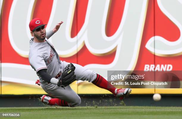 Cincinnati Reds right fielder Jesse Winker slips as he chases down a double by the St. Louis Cardinals' Matt Carpenter in the fifth inning on...