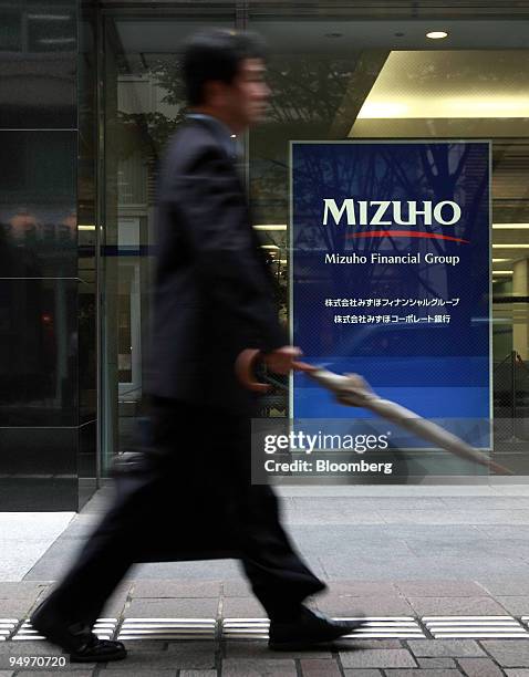 Man walks past the Mizuho Financial Group Inc. Headquarters in Tokyo, Japan, on Friday, July 31, 2009. Mizuho Financial Group Inc., Japan's...