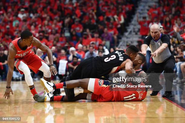 Jrue Holiday of the New Orleans Pelicans and CJ McCollum of the Portland Trail Blazers grab a loose ball during the first half of Game Four of the...