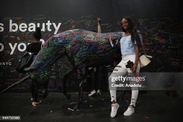 Costumer poses by a wall that reads "What does beauty mean to you?" during BeautyCon 2018 festival in Jacob K. Javits Convention Center in New York,...