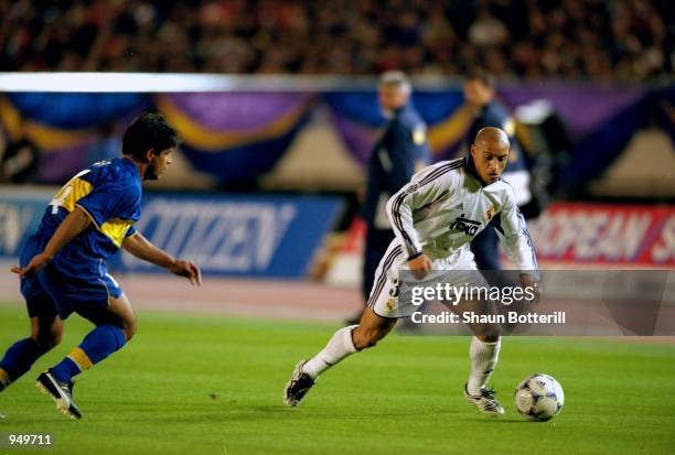 Roberto Carlos of Real Madrid goes down the wing while being closely watched by Hugo Ibarra of Boca Juniors during the Toyota Intercontinental Cup...