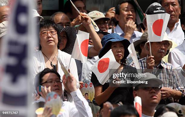 People listen to a speech by Taro Aso, Japan's prime minister and president of the Liberal Democratic Party , unseen, during a campaign rally for the...