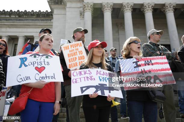 School teachers Kimberly Corvin and Lori Gauthier and Gauthier's mom Diane Miller, all of Lakewood, Washington, hold signs during the "March for Our...