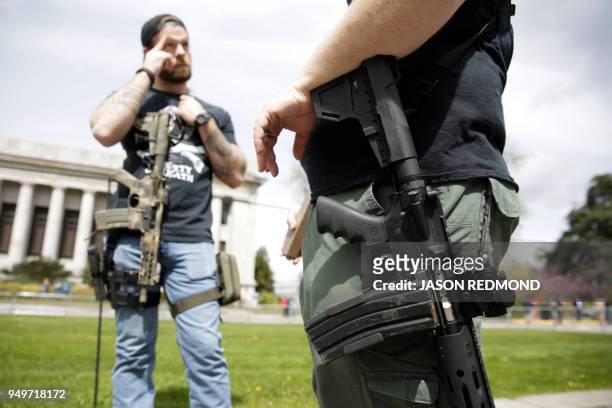 Gun advocates are pictured with firearms in front of the Washington state capitol during the "March for Our Rights" pro-gun rally in Olympia,...