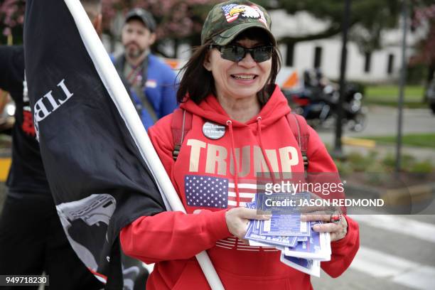 Trump supporter hands out flyers for a local politician at the Washington state capitol during the "March for Our Rights" pro-gun rally in Olympia,...
