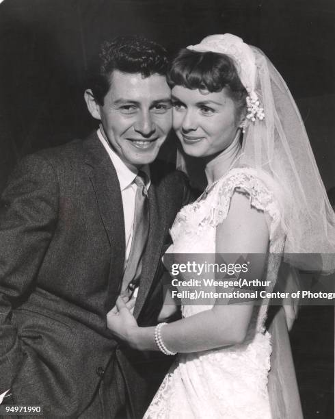 Wedding photo of singer and performer Eddie Fisher with actress Debbie Reynolds, wearing wedding gown, Grossinger, NY, 1955.