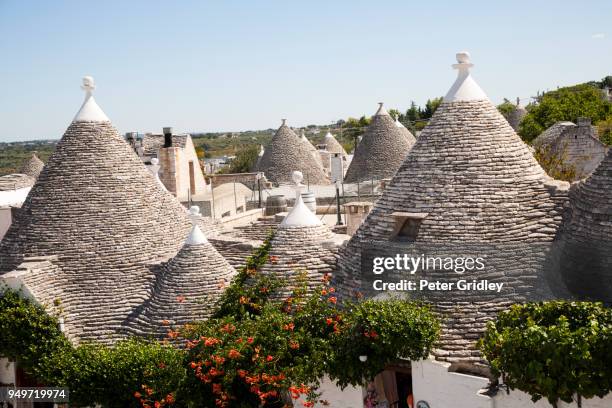 conical stone roofs of unique trulli houses in alberobello, italy - trulli photos et images de collection