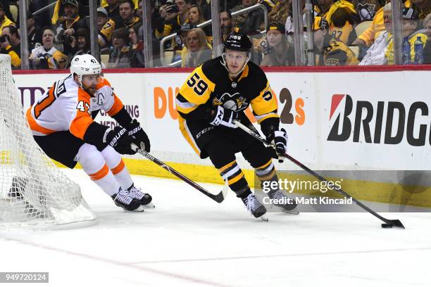 Jake Guentzel of the Pittsburgh Penguins brings the puck out from behind the net against Andrew MacDonald of the Philadelphia Flyers in Game Five of...