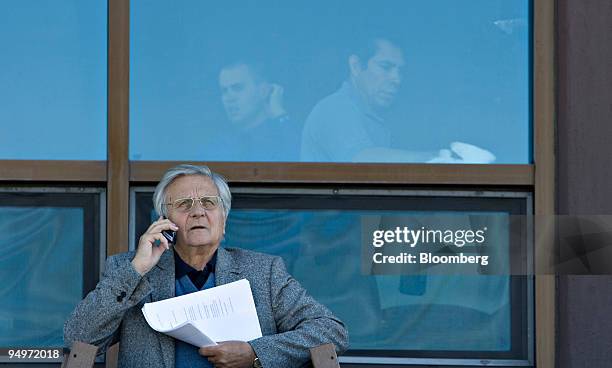 Jean-Claude Trichet, president of the European Central Bank, talks on a cell phone outside the Jackson Lake Lodge during a coffee break at the...