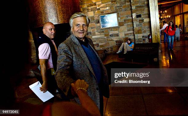 Jean-Claude Trichet, president of the European Central Bank, shakes hands with a journalist as he leaves a session during the Jackson Hole Economic...