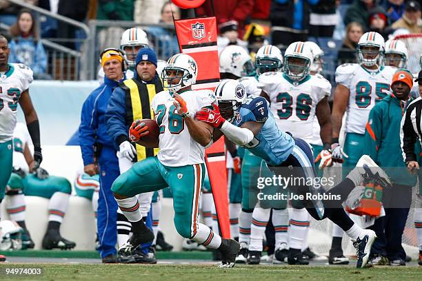 Keith Bulluck of the Tennessee Titans tackles Lex Hilliard of the Miami Dolphins at LP Field on December 20, 2009 in Nashville, Tennessee. The Titans...