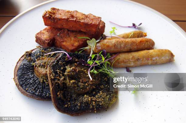 pesto mushrooms, hash browns and pork chipolata sausages on a round plate - field mushroom stock pictures, royalty-free photos & images