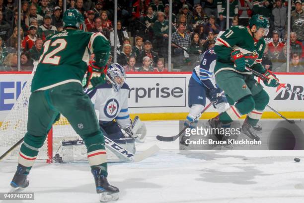 Connor Hellebuyck of the Winnipeg Jets defends his goal against Eric Staal and Zach Parise of the Minnesota Wild in Game Three of the Western...