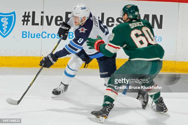 Andrew Copp of the Winnipeg Jets passes the puck with Carson Soucy of the Minnesota Wild defending in Game Three of the Western Conference First...