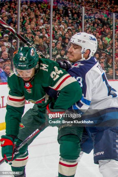 Matt Dumba of the Minnesota Wild and Brandon Tanev of the Winnipeg Jets battle for the puck in Game Three of the Western Conference First Round...