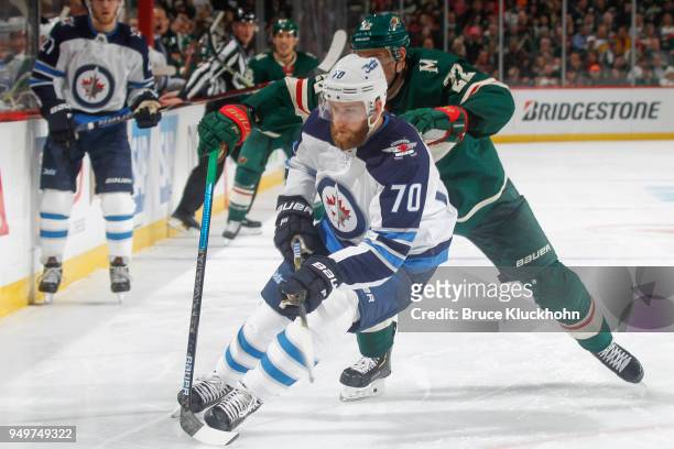 Nino Niederreiter of the Minnesota Wild defends Joe Morrow of the Winnipeg Jets in Game Three of the Western Conference First Round during the 2018...
