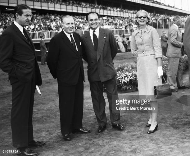 Charles E Wacker III, John W Hanes, Prince Aly Khan, and C.Z. Guest, standing close to the track at the Aqueduct Race Course, NY, c1959. Khan was the...