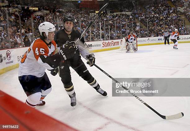 Arron Asham of the Philadelphia Flyers is lined up by Eric Godard of the Pittsburgh Penguins at the Mellon Arena on December 15, 2009 in Pittsburgh,...