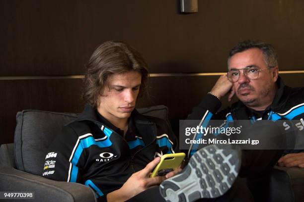 Niccolo Bulega of Italy and Sky Racing Team VR46 KTM looks on the mobile phone with his father in media center during the MotoGp Red Bull U.S. Grand...