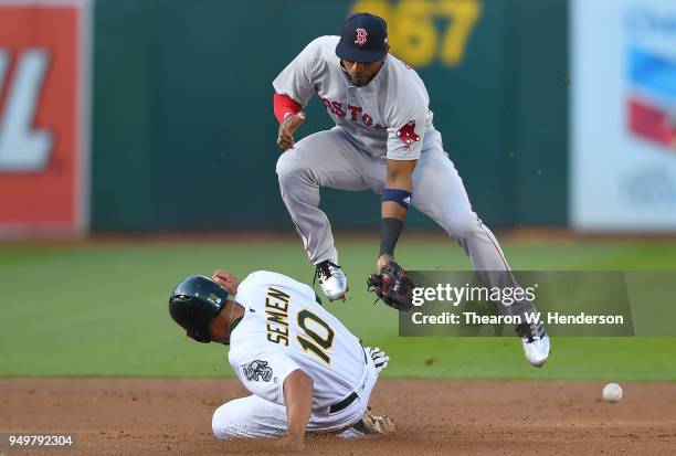 Marcus Semien of the Oakland Athletics steals second base beating the throw down to Eduardo Nunez of the Boston Red Sox in the bottom of the first...