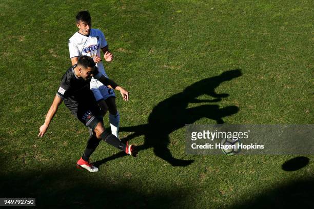 Justin Gulley of Team Wellington passes under pressure from Emiliano Tade of Auckland City FC during leg one of the OFC Champions League 2018...