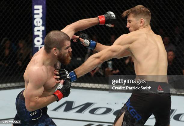Jim Miller punches Dan Hooker of New Zealand in their lightweight fight during the UFC Fight Night event at the Boardwalk Hall on April 21, 2018 in...