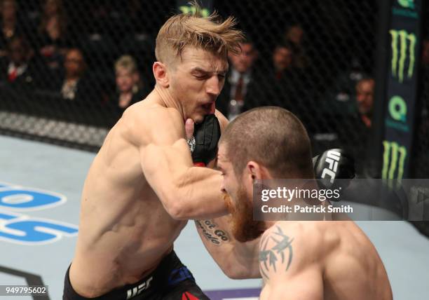 Dan Hooker of New Zealand punches Jim Miller in their lightweight fight during the UFC Fight Night event at the Boardwalk Hall on April 21, 2018 in...