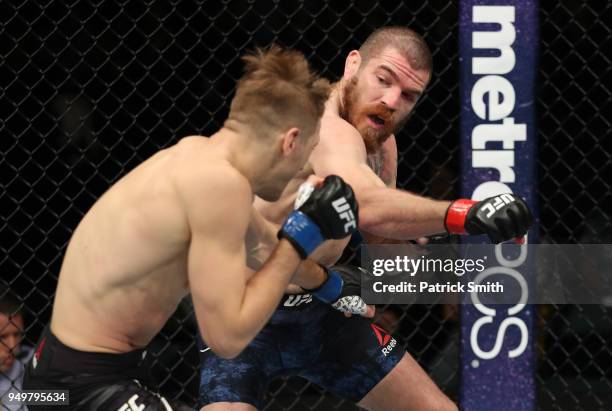 Jim Miller punches Dan Hooker of New Zealand in their lightweight fight during the UFC Fight Night event at the Boardwalk Hall on April 21, 2018 in...