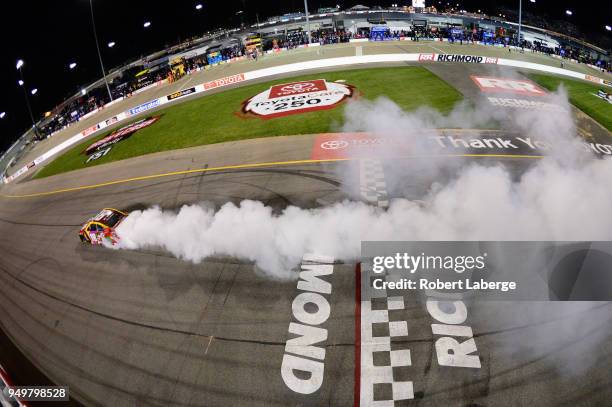 Kyle Busch, driver of the M&M's Flavor Vote Toyota, celebrates with a burnout after winning the Monster Energy NASCAR Cup Series Toyota Owners 400 at...