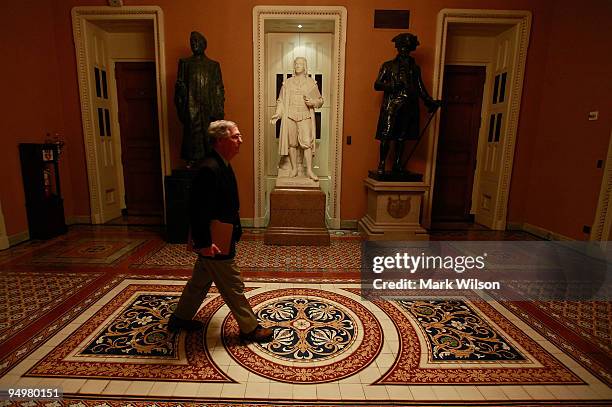 Senate Republican Leader Mitch McConnell walks through the Capitol after the Senate passed a procedural vote on health are reform on December 21,...