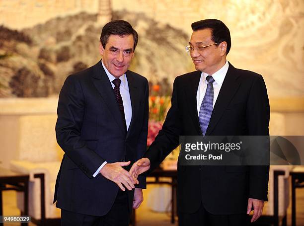 French Prime Minister Francois Fillon is greeted by Chinese Vice-Premier Li Keqiang as they attend a ceremony confirming a nuclear power cooperation...