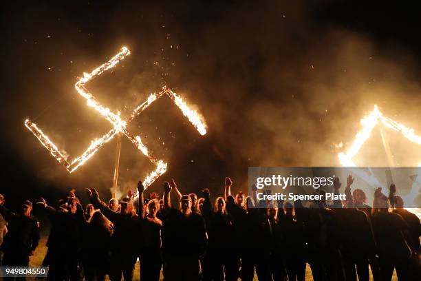 Members of the National Socialist Movement, one of the largest neo-Nazi groups in the US, hold a swastika burning after a rally on April 21, 2018 in...