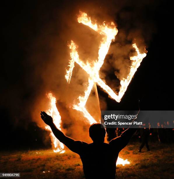 Members of the National Socialist Movement, one of the largest neo-Nazi groups in the US, hold a swastika burning after a rally on April 21, 2018 in...