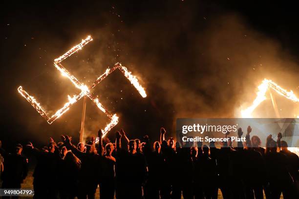 Members of the National Socialist Movement, one of the largest neo-Nazi groups in the US, hold a swastika burning after a rally on April 21, 2018 in...