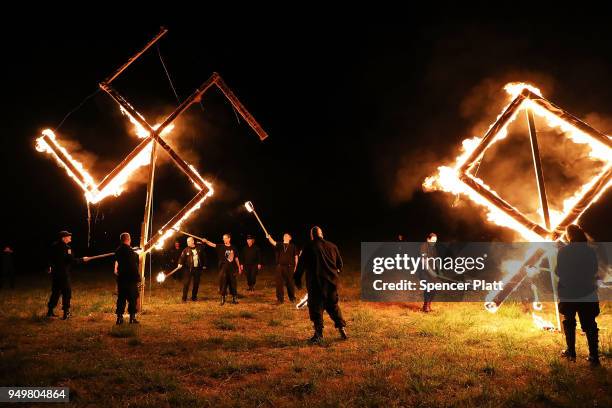 Members of the National Socialist Movement, one of the largest neo-Nazi groups in the US, hold a swastika burning after a rally on April 21, 2018 in...